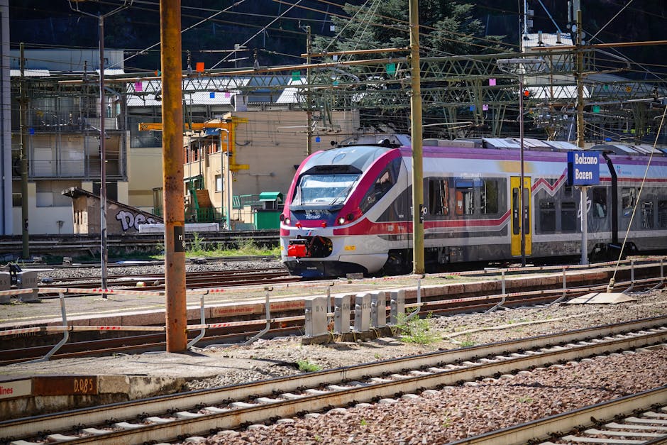 Bolzano’da dağ manzaralı tren istasyonu önünde yolcular
