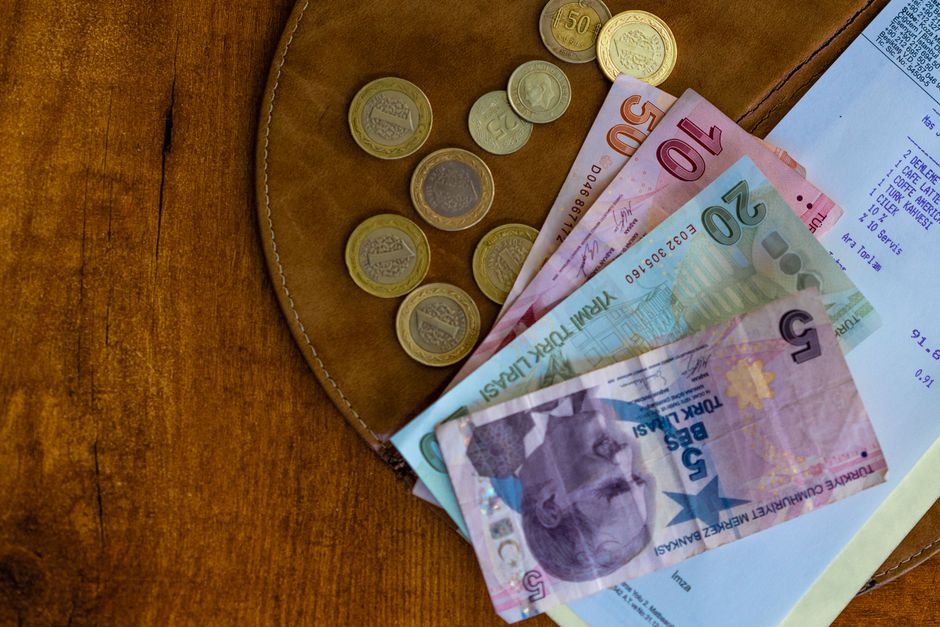 Seyahat bütçesi için plan yapan bir yolcünün büyük bir harita ve not defteriyle çalışması