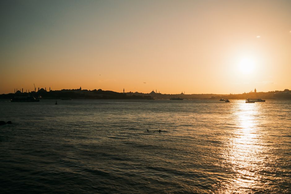 Boğazda gün batımı manzarasını gören turistler
